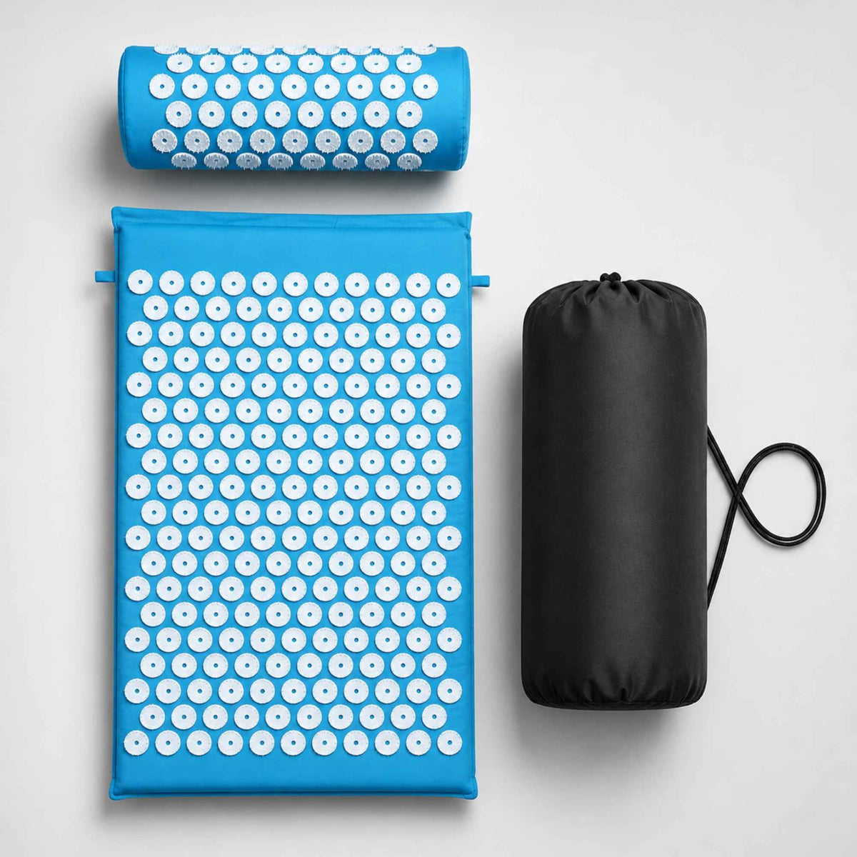 Kit de tapis d’acupression bleu clair avec coussin cervical et sac de transport sur fond blanc.