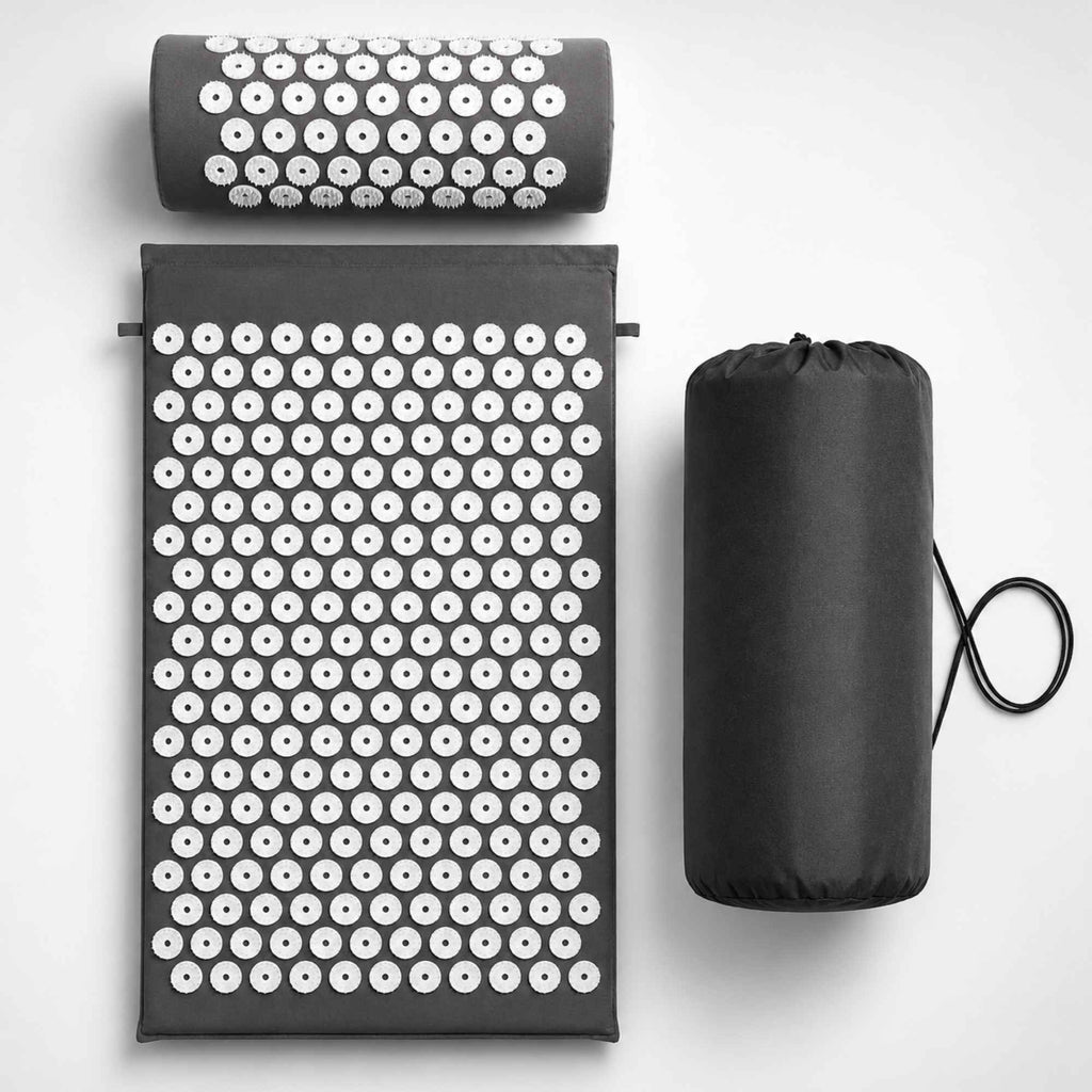 Kit de tapis d’acupression gris avec coussin cervical et sac de transport sur fond blanc.