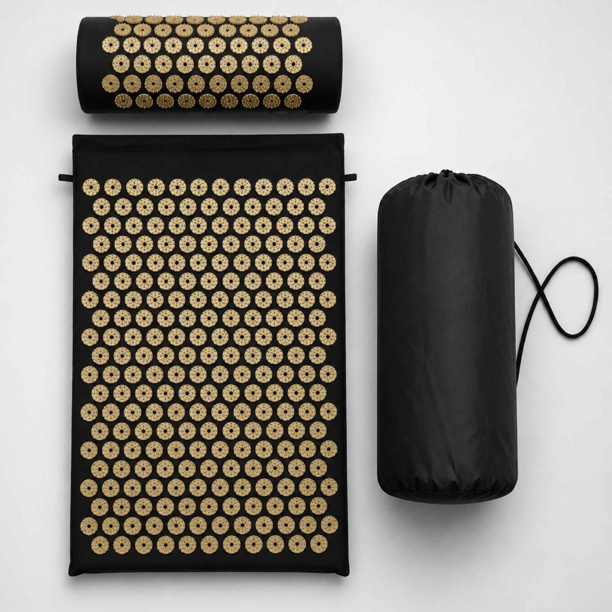 Ensemble de tapis d’acupression noir avec picots dorés comprenant un tapis, un coussin cervical et un sac de rangement sur fond blanc.